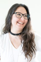 A headshot-style photo of lily smiling, set against a white background, her long brown hair brushed to the side.
